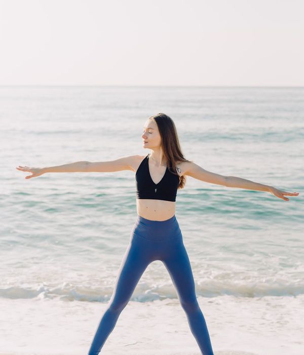 Woman in a flowing yoga pose on a sunny morning, radiating peace.